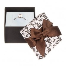 Weißschwarze Geschenkverpackung mit Ornamenten und brauner Schleife